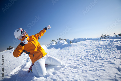 cool guy with ski helmet kneeling in snow