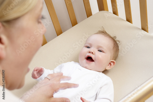 Fotografija Mother Playing With Baby In Cot