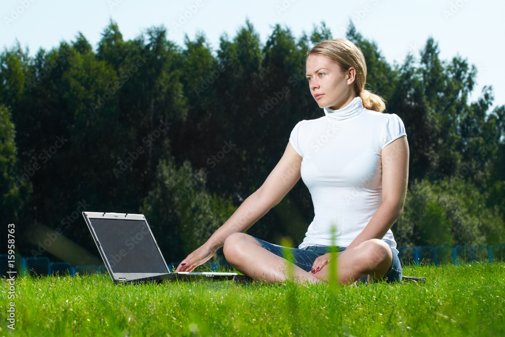 The girl with laptop on a green lawn The girl with laptop on a green lawn
