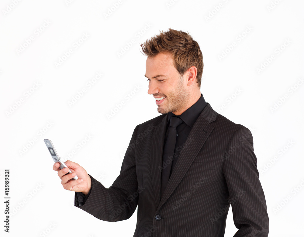 Smiling businessman writing a message with a mobile phone Smiling businessman writing a message with a mobile phone