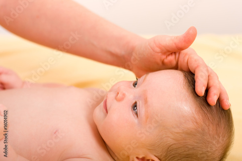 Tableau sur toile Smiling baby and an adult 's hand.