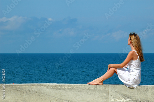 Woman sits and looks at the sea