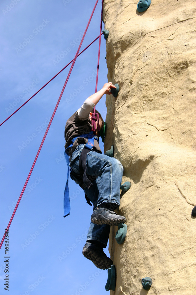Fototapeta premium Kind klettert an Kletterwand