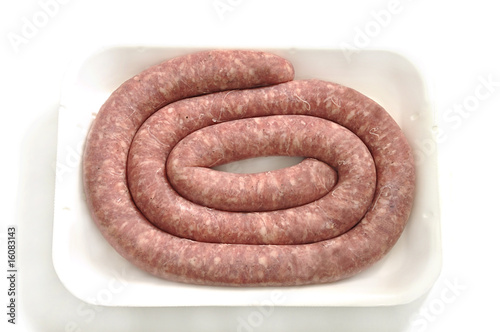 Raw sausage on white tray.