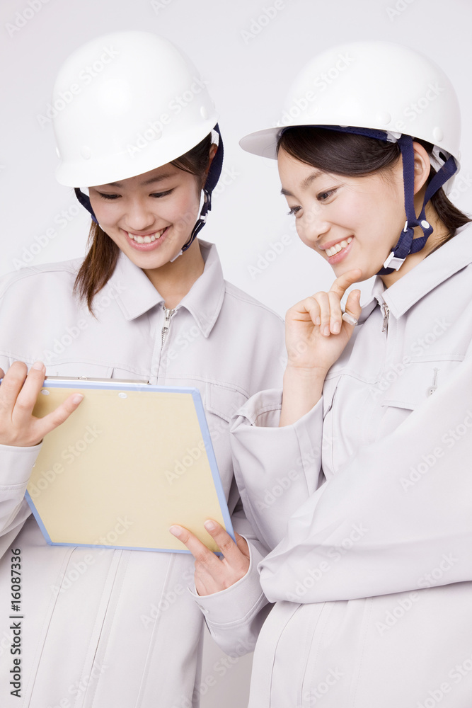 資料を見る女性作業員2名 資料を見る女性作業員2名