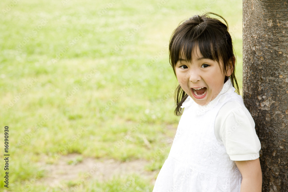 木に寄り掛かって遊ぶ女の子 木に寄り掛かって遊ぶ女の子