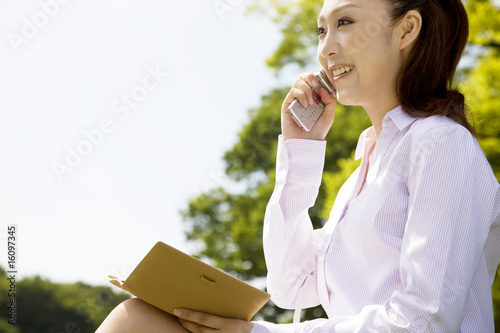 Fototapeta Naklejka Na Ścianę i Meble -  携帯電話で会話をする女性