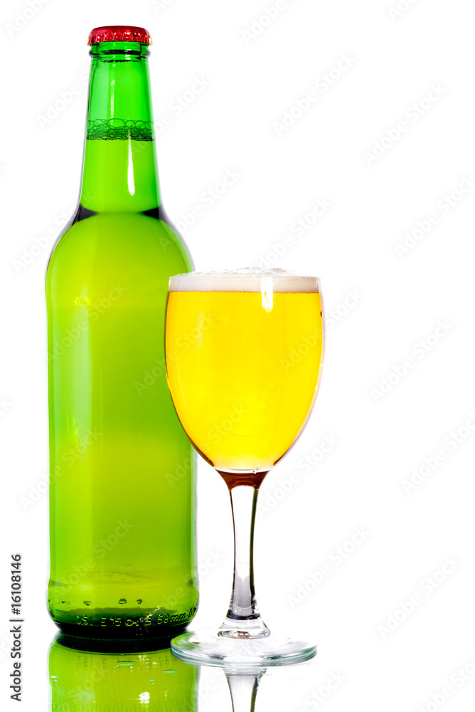 Glass of beer in the front with foam with green bottle of beer Glass of beer in the front with foam with green bottle of beer