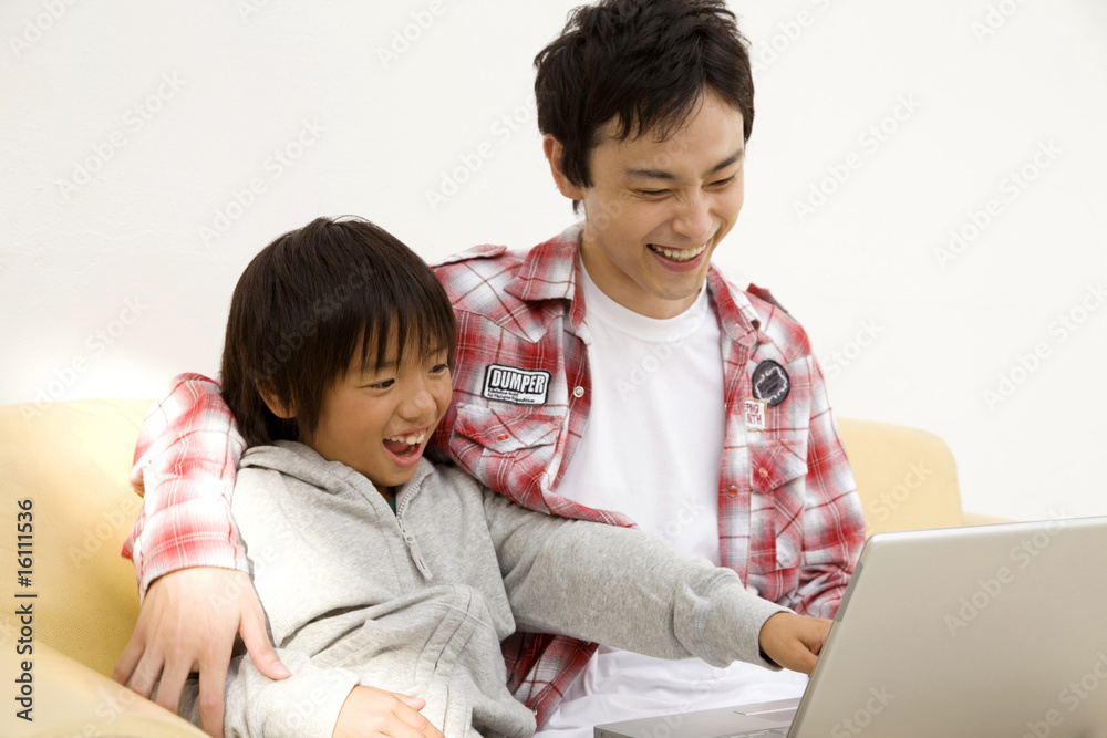 ノートパソコンで遊ぶ親子