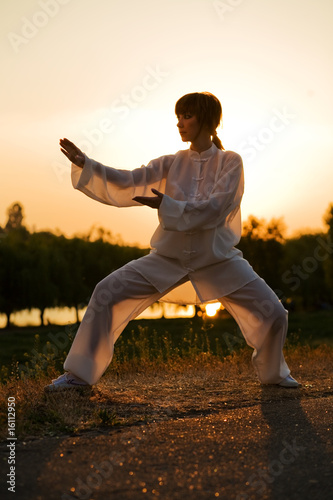 woman in white suit make's taiji chuan exercise - 9