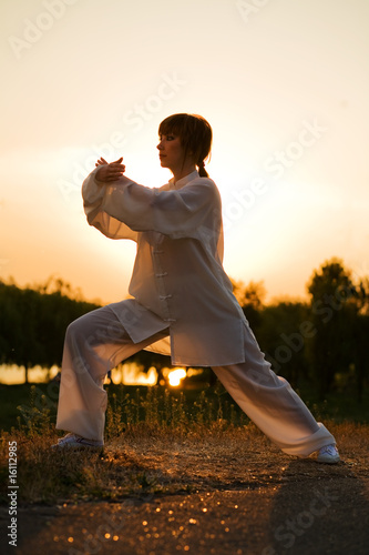 woman in white suit make's taiji chuan exercise - 8