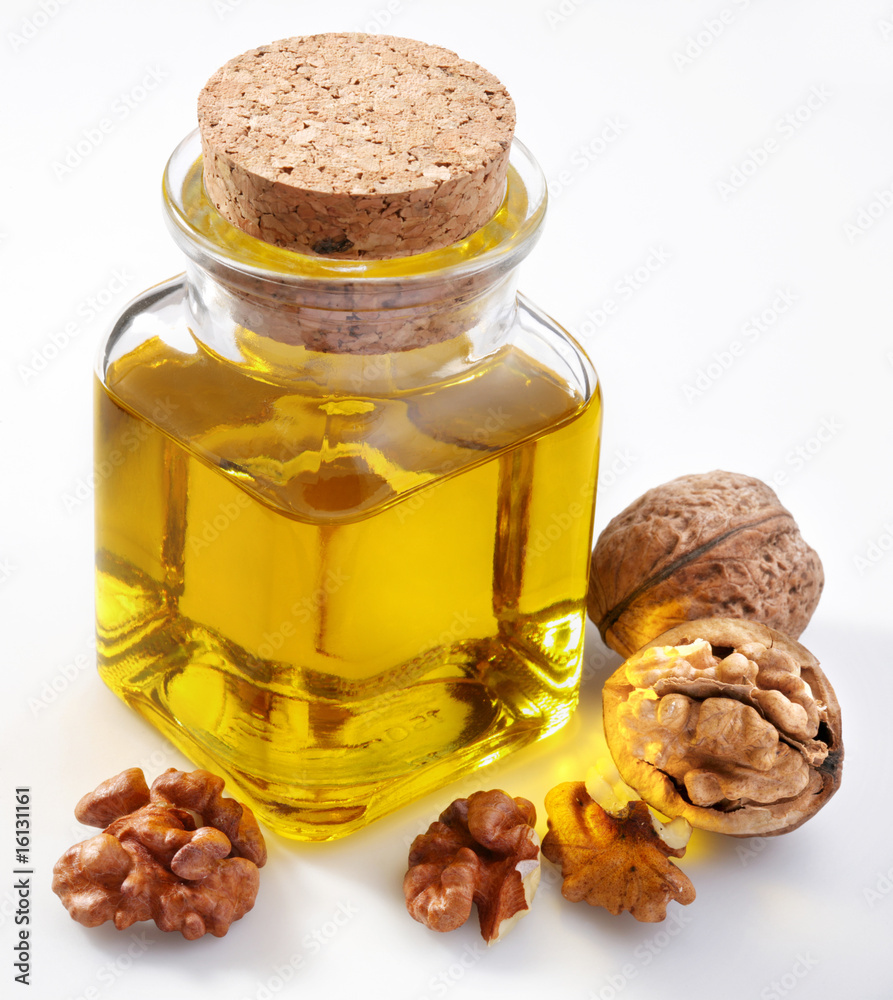 Walnut oil with nuts on a white background Walnut oil with nuts on a white background