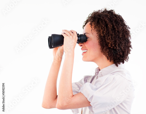 Smiling brunette businesswoman looking through binoculars