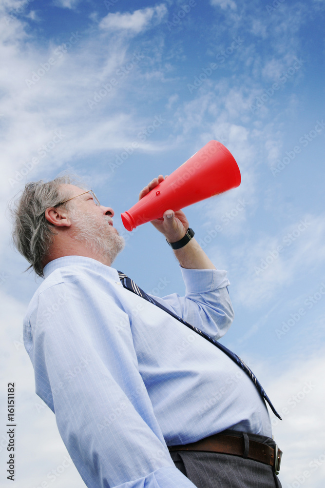 Senior business man shooting through a megaphone Senior business man shooting through a megaphone