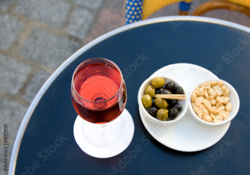Kir cassis and nibbles. Focus on wine glass