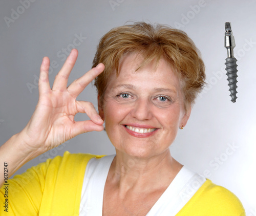 Canvas Print elderly woman with gesture OK dental implant