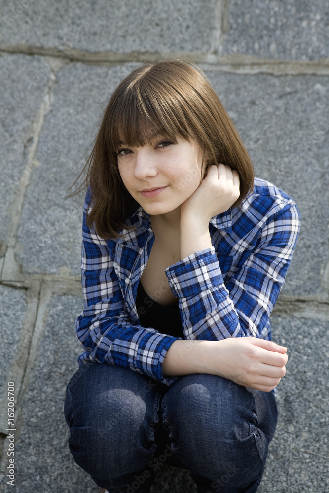 portrait of young teen girl sitting at stone wall portrait of young teen girl sitting at stone wall