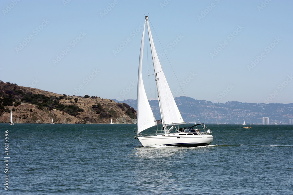 Fototapeta premium voilier blanc tanguant dans la baie