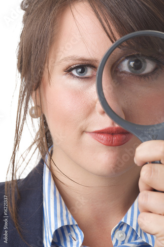 Young business woman looking through a magnifying glass