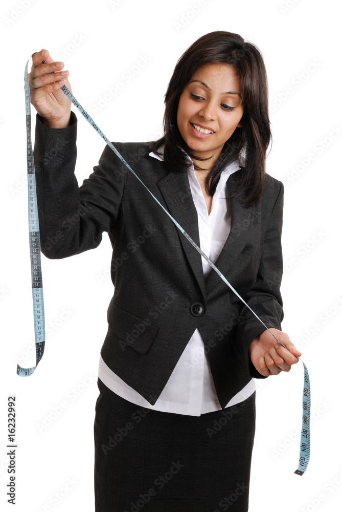 Business woman looking at a measuring tape Business woman looking at a measuring tape