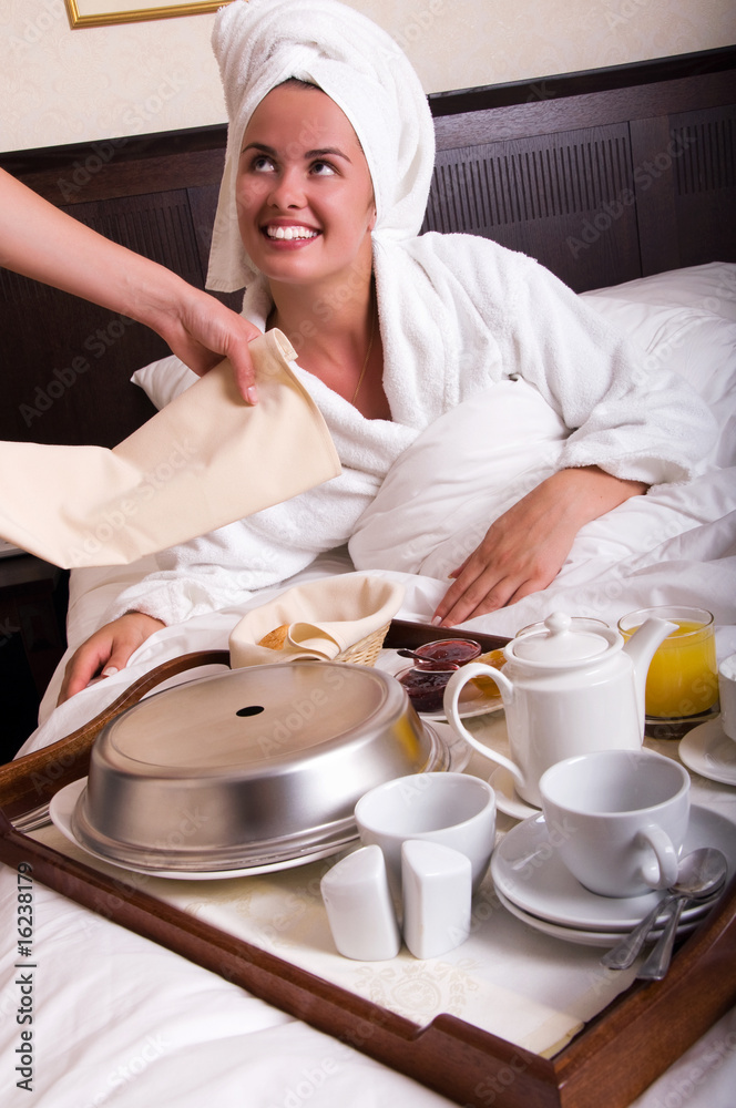 Young beautiful woman with breakfast in bed