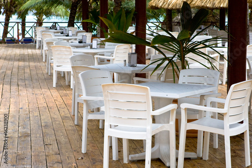 Many white plastic chairs and tables