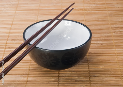 Chopsticks with  ceramic bowl on bamboo mat
