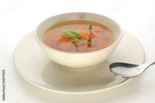 carrot soup with fresh organic herbs in a bowl