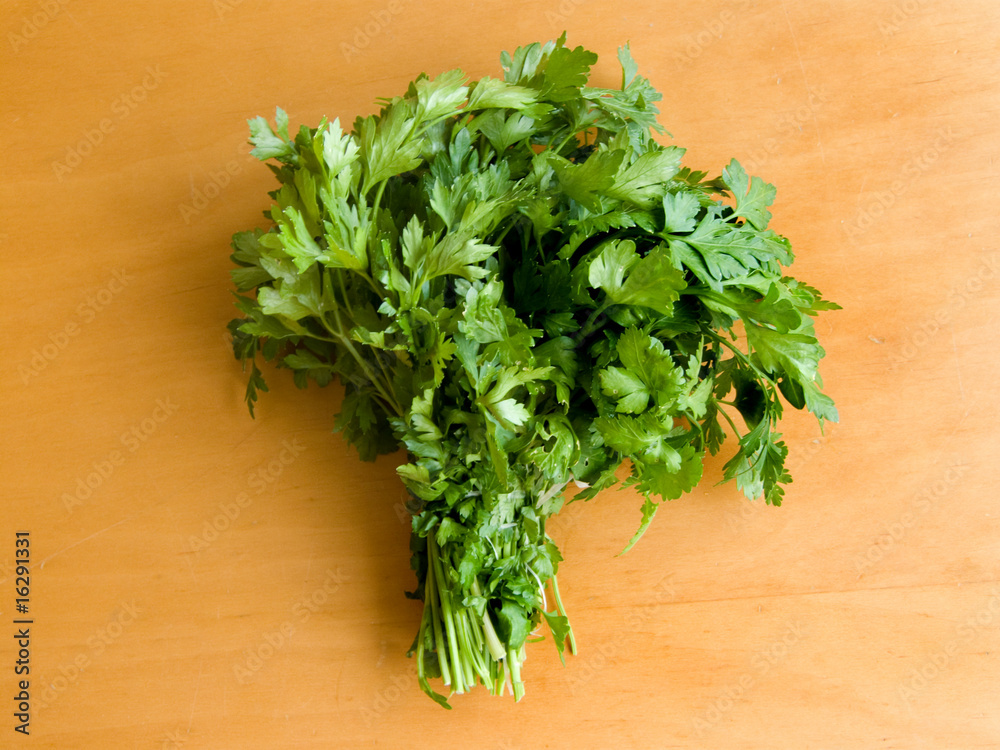 Fresh curly parsley on the wooden table. Up view. Fresh curly parsley on the wooden table. Up view.