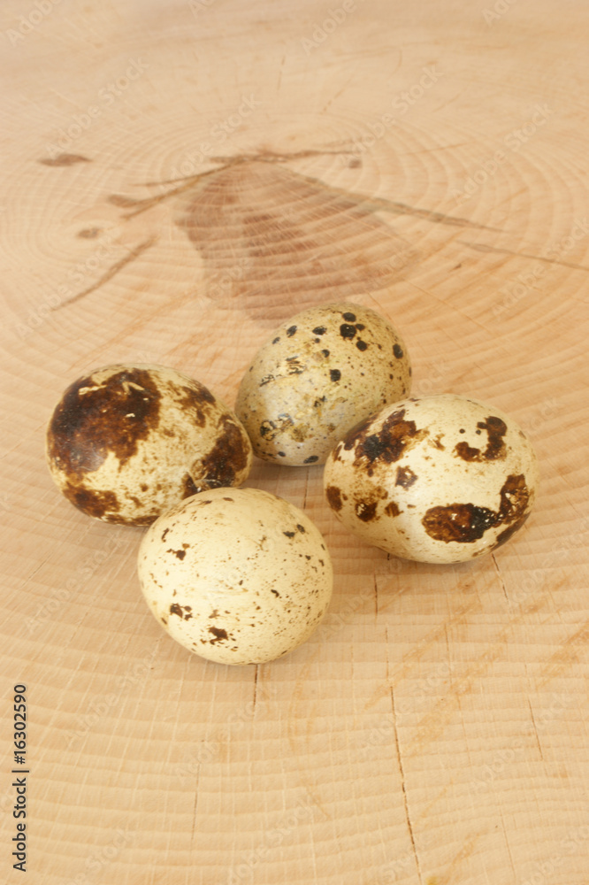 Fototapeta premium four organic quail eggs on a timber board