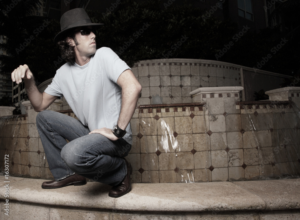 Man squatting and looking over his shoulder