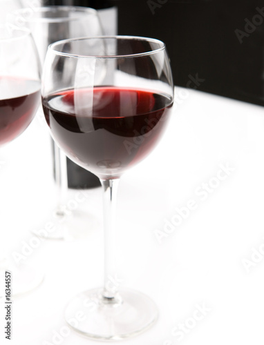 Glasses of red whine on white table cloth.
