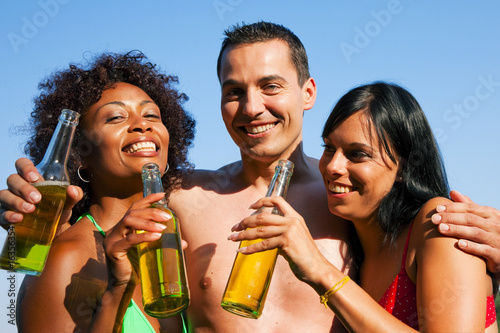 Freunde trinken Bier in Sommerlaune am See