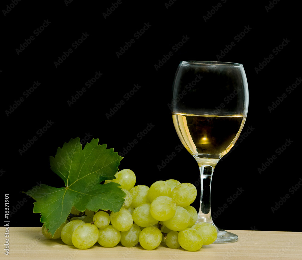 Goblet with wine and grapevine isolated on black background