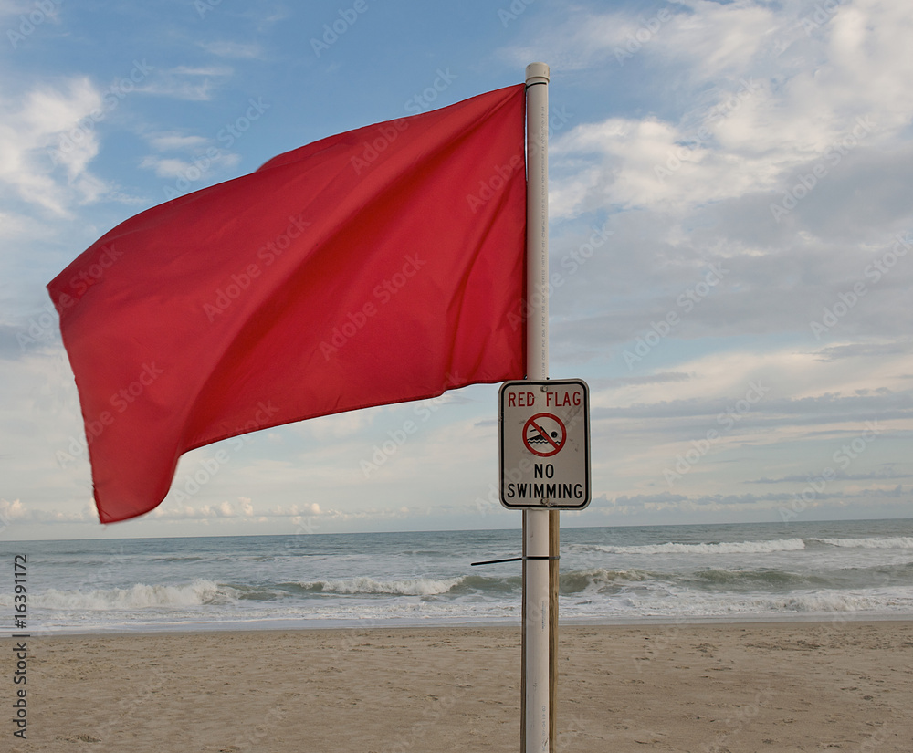 Red flag at the beach during hurricane season to warn of danger. Stock