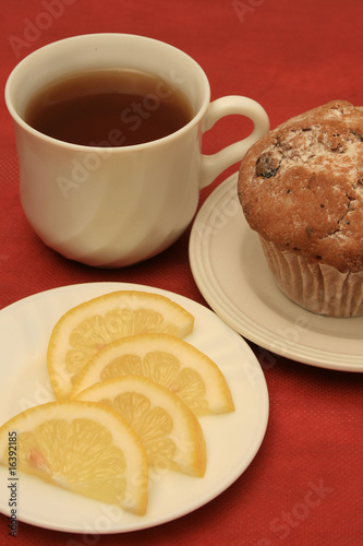 A cup of tea with leamon and a cup cake