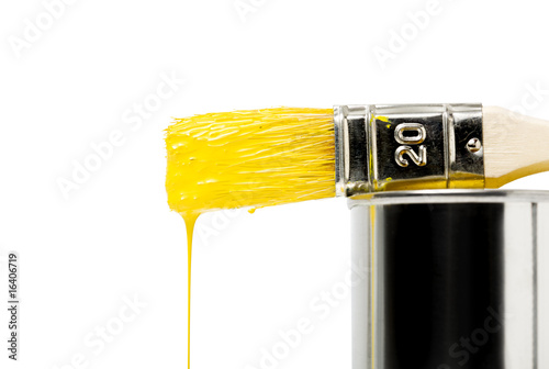 gelbe farbe tropft von einem pinsel auf einer farbdose