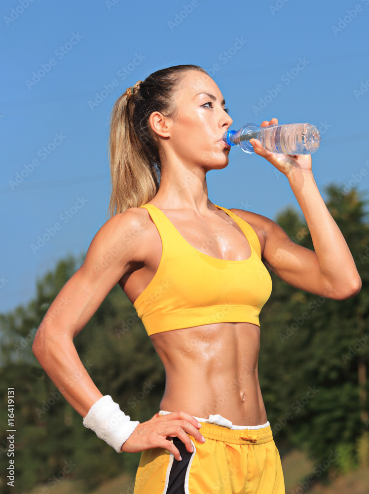 Athlete woman drinking water from a plastic bottle Athlete woman drinking water from a plastic bottle