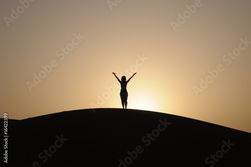 donna con le braccia alzate nel deserto