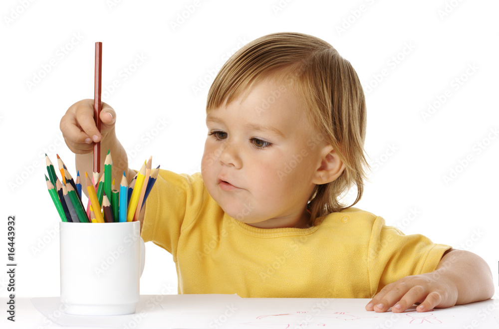 Child picking a crayon from the cup Child picking a crayon from the cup