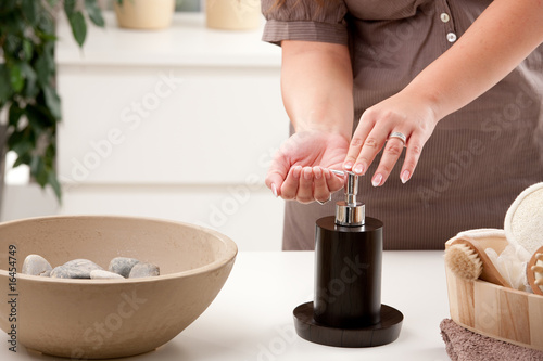 Female hands using liquid soap