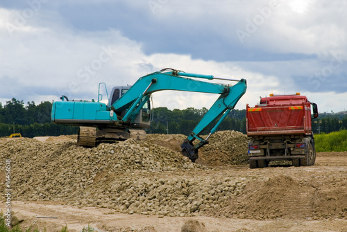 Excavator loading sand or rocks in lorry