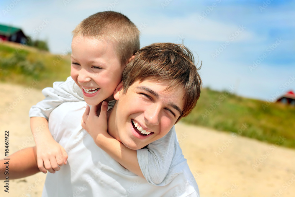 Fototapeta premium happy teenager and kid on the beach