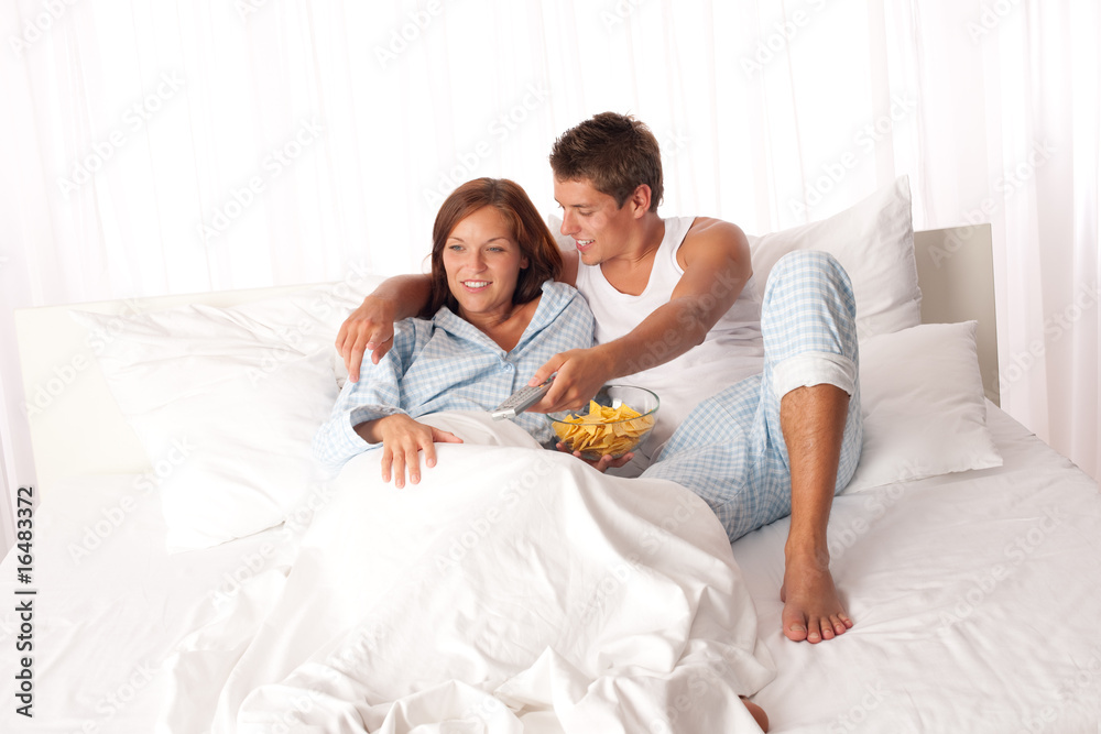 Fototapeta premium Young man and woman lying down in white bed