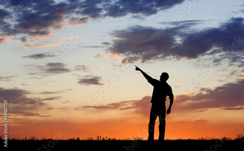 Silhouette of man pointing during dawn or evening