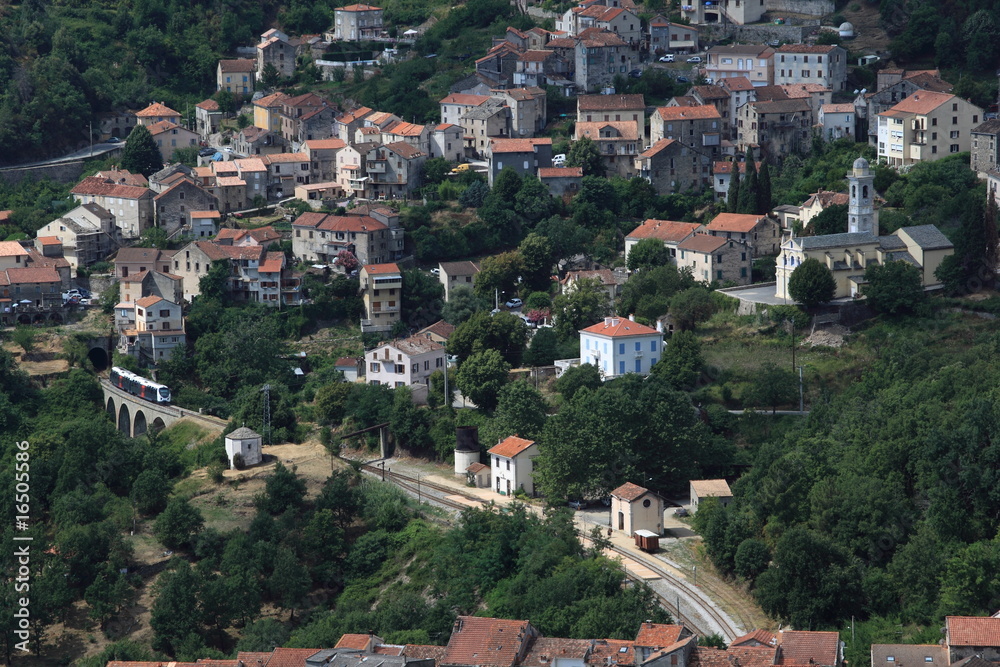 Mountain village in Corsica with a train going over a viaduct