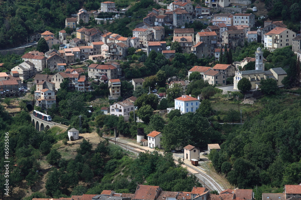Mountain village in Corsica with a train going over a viaduct Mountain village in Corsica with a train going over a viaduct