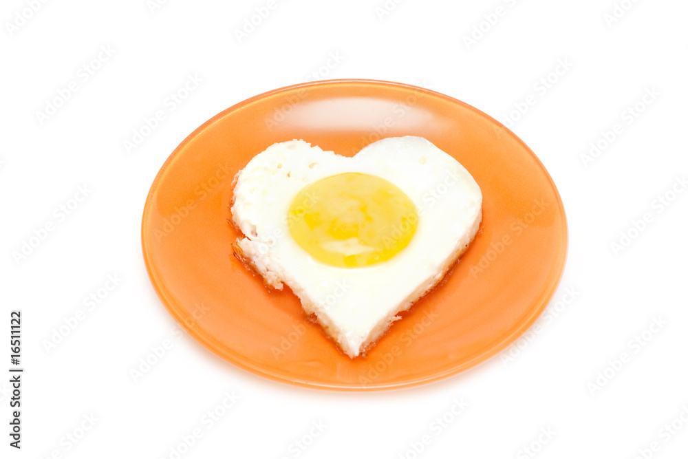Fried egg in form heart on plate