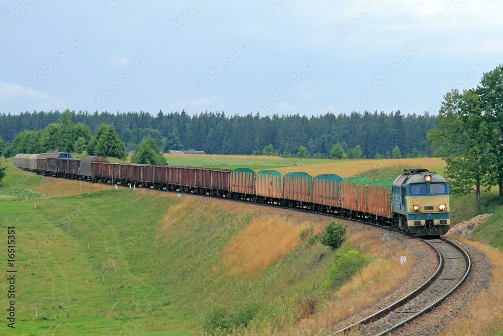 Freight train passing the hilly landscape Freight train passing the hilly landscape