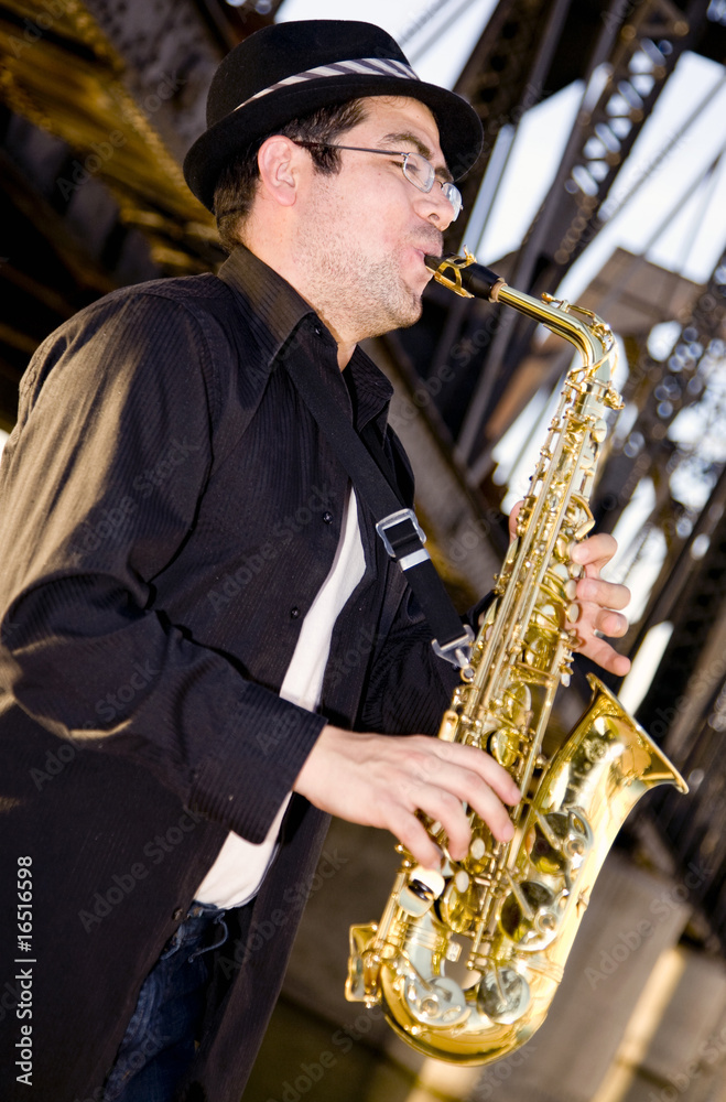 Fototapeta premium saxophonist plays outdoors at sunset